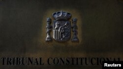 FILE - A plaque is seen at the entrance of Spain's Constitutional Court building in Madrid, Spain, Sept. 6, 2017. A Spanish a court handed down a two-year prison sentence to a journalist accused of revealing details from a judicial investigation.