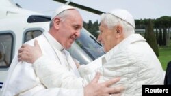 FILE - Pope Francis (L) embraces Pope Emeritus Benedict XVI as he arrives at the Castel Gandolfo summer residence, Italy, March 23, 2013. 