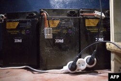 Des batteries rechargeables utilisées par les conducteurs de motos électriques sont rechargées dans un magasin de Cotonou le 21 octobre 2022.