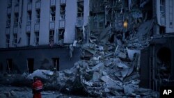 Un trabajador de emergencia camina frente a un hotel dañado luego de un ataque ruso en Kiev, Ucrania, el 31 de diciembre de 2022.