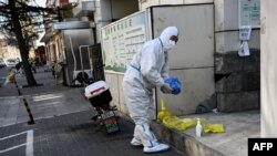 A worker wearing personal protective equipment (PPE) during the Covid-19 pandemic is seen along a street in Beijing, China, Dec. 11, 2022. 