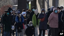 北京居民在一所医院的发热门诊前大排长龙。（美联社2022年12月11日照片）