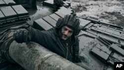A Ukrainian soldier looks out of a captured Russian tank on the front line in Ukraine's Donetsk region, Nov. 22, 2022.