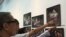 Visitors point to photos of Em Theay, now 85, taken by photographer Aray Steven, on display at National Museum in Phnom Penh, November 1, 2015. (Photo: Phorn Bopha/VOA Khmer) 