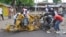 People inspect a damaged tricycle at the site of a bomb explosion, caused by a female suicide bomber in a market in Maiduguri, Nigeria, July 31, 2015. 