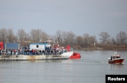 People arrive by ferry after fleeing from Russia's invasion of Ukraine, at the Isaccea-Orlivka border crossing, Romania, March 14, 2022.
