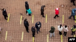 Residents queue to undergo nucleic acid tests for the Covid-19 coronavirus in Jilin in China's northeastern Jilin province on March 12, 2022.