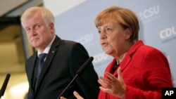 German Chancellor Angela Merkel, right, and the Governor of the German State of Bavaria, Horst Seehofer, left, address the media in Berlin, about their talks on the migrant influx, Nov. 3, 2015. 
