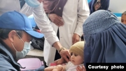 WHO Representative in Afghanistan Dr Luo Dapeng joins the measles vaccination campaign and vaccinates a child in Wardak Province on 13 March 2022. (Courtesy photo/WHO)