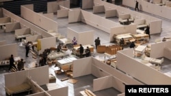 Workers set up beds inside a stadium to convert it into a makeshift hospital for coronavirus disease (COVID-19) in Changchun, Jilin province, China, March, 15, 2022. (China Daily via Reuters) 