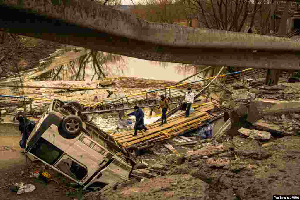 Civilians cross the Irpin River that divides the little town of Irpin from Kyiv. Irpin, Ukraine, March 12, 2022. (Yan Boechat/VOA)