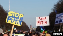 Las personas llevan banderas y pancartas durante una manifestación contra la guerra "Alto a la guerra. Paz y solidaridad para el pueblo de Ucrania", para protestar contra la invasión rusa de Ucrania, en la Strasse des 17. Juni, cerca de la Puerta de Brandenburgo, en Berlín. Alemania, 13 de marzo de 2022. REUTERS/Lisi Niesner