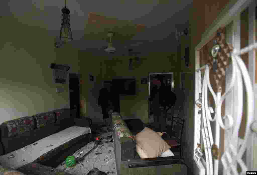 Men inspect their home, which was damaged after a car bomb attack in Baghdad, Feb. 3, 2014. 