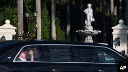 প্রেসিডেন্ট ডনাল্ড ট্রাম্প ফ্লোরিডায় ওয়েস্ট পাম বীচে তার গলফ ক্লাবে পৌঁছেছেন; লিমুজিন থেকে তিনি হাত নাড়ছেন। ফটোঃ ৮ মার্চ, ২০২৫।