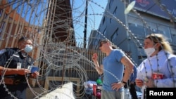 An U.S. Customs and Border Protection agent listens to Russians seeking for a humanitarian visa at the San Ysidro Port of Entry of the U.S.-Mexico border in Tijuana, Mexico, March 15, 2022.
