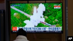 Seorang pengunjung menonton layar TV yang menayangkan berita tentang rudal Korea Utara di sebuah stasiun kereta api di Seoul, Korea Selatan, Jumat, 11 Maret 2022. (Foto: AP)