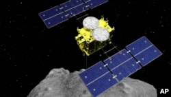 FILE - A computer-rendered image released by the Japan Aerospace Exploration Agency (JAXA) shows the Hayabusa2 spacecraft above the asteroid Ryugu.