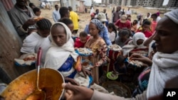 FILE - Tigrayans queue to receive food donated by local residents at a reception center for the internally displaced, in Mekele, in Ethiopia's Tigray region, May 9, 2021. 