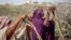 FILE - Somali women who fled drought-stricken areas build shelters near Mogadishu, Somalia, Feb. 4, 2022. International Women's Day on March 8, 2025, honors women worldwide for their resilience amid conflict. This year's theme calls for action that unlocks equal rights for all.