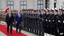 FILE - U.S. President Joe Biden walks past an honor guard with Polish President Andrzej Duda, at the Presidential Palace in Warsaw, Poland, March 26, 2022.