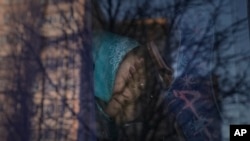 A refugee cries on a bus while waiting for Ukrainian police to check papers and belongings in Brovary, Ukraine, Sunday, March 20, 2022.