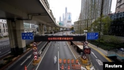 Seorang petugas mengenakan APD berjalan di pintu masuk ke terowongan yang mengarah ke daerah Pudong,seberang sungai Huangpu, di tengah lockdown akibat pandemi COVID-19 di Shanghai, China 28 Maret 2022. (REUTERS/Aly Song)