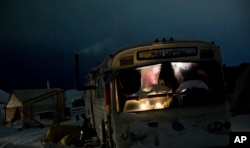 A bus has become a camper at the Oceti Sakowin camp, where people have gathered to protest the Dakota Access pipeline near Cannon Ball, N.D., Nov. 30, 2016. The camp covers a half square mile, with living quarters that include old school buses, fancy motorhomes and yurts.