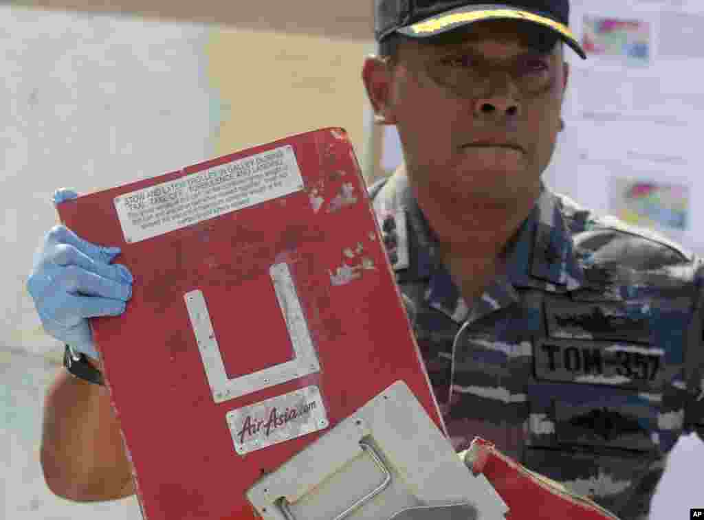 Commander of Indonesian Navy ship KRI Bung Tomo Col. Yayan Sofyan holds a piece of the AirAsia Flight 8501 recovered in search operations for the ill-fated jetliner, during a press conference at the Navy&#39;s Eastern Fleet Naval Base in Surabaya, East Java, Indonesia, Jan. 5, 2015.