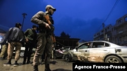 A Syrian fighter stands guard at the scene of an explosion that took place at the popular market of the Turkish-controlled city of al-Bab in Syria's northern Aleppo province on the border with Turkey, Jan. 13, 2022.