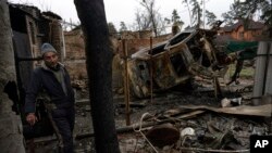 Un homme se tient dans ce qui était l'intérieur d'une maison détruite à Irpin, à la périphérie de Kiev, en Ukraine, le 2 avril 2022.