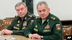 FILE: Russian Defense Minister Sergei Shoigu, right, and Head of the General Staff of the Armed Forces of Russia and First Deputy Defense Minister Valery Gerasimov listen to Russian President Vladimir Putin in Moscow, Russia, Feb. 27, 2022.