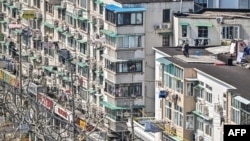 Residents stand on the rooftop of a building during the second stage of a Covid-19 lockdown in the Jing'an district in Shanghai on April 3, 2022.