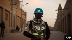 FILE - Policemen of the United Nations Stabilization Mission in Mali (MINUSMA) patrol in front on the Great Mosque in Timbuktu, Mali, Dec. 8, 2021.