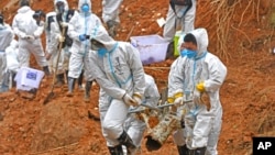 FILE - In this photo released by Xinhua News Agency, rescuers carry a piece of plane wreckage at the site of Monday&#39;s plane crash in Tengxian County, southern China&#39;s Guangxi Zhuang Autonomous Region, on March 25, 2022.