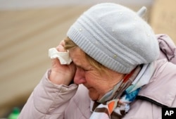 A woman named Svetlana, who traveled from Kharkiv, cries as she waits in a queue with other fleeing the war from neighboring Ukraine, at the border crossing in Medyka, southeastern Poland, on March 29, 2022.