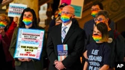 FILE - People gather to protest against HB1041, a bill to ban transgender women and girls from participating in school sports that match their gender identity, at the Statehouse in Indianapolis, Feb. 9, 2022.