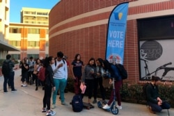 FILE - Young voters wait on line at a polling station at the University of Southern California, in Los Angeles, March 3, 2020.