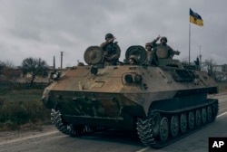 Ukrainian soldiers ride a captured Russian APC in Kherson, Ukraine, Sunday, Nov. 13, 2022.