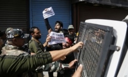 FILE - Indian policemen detain Kashmiri Muslims as they shout pro-freedom slogans, in Srinagar, Indian-controlled Kashmir, Sept. 8, 2019.