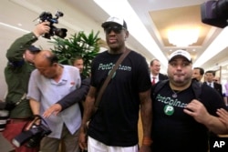 Former NBA basketball star Dennis Rodman, center, arrives at Sunan International Airport on June 13, 2017, in Pyongyang, North Korea.