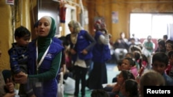 FILE - Syrian refugee children play as they wait with their families to register their information at the U.S. processing center for Syrian refugees in Amman, Jordan, April 6, 2016.