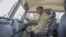 FILE - A Zambian army soldier is seen inside a military truck as other patrol the Chawama Compound in Lusaka on Aug. 3, 2021.