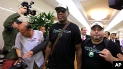 Former NBA basketball star Dennis Rodman, center, arrives at Sunan International Airport on June 13, 2017, in Pyongyang, North Korea. 