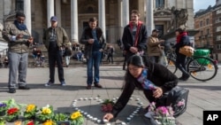 Une femme installe des bougies en forme de cœur à Bruxelles, le mardi 22 mars 2016.