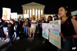 A crowd of people gather outside the Supreme Court, early Tuesday, May 3, 2022 in Washington. A draft opinion circulated among Supreme Court justices suggests that earlier this year a majority of them had thrown support behind overturning the 1973 case Roe v. Wade that legalized abortion nationwide, according to a report published Monday night in Politico. (AP Photo/Alex Brandon)