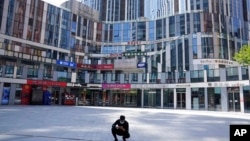 一名男子蹲在北京一處被關閉了的商場前。（ 2022年5月2日