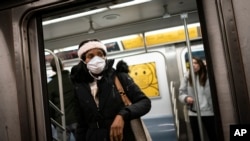 Mass transit riders wear masks as they commute in New York, April 19, 2022. On Tuesday, U.S. health officials recommended Americans wear masks on planes, trains and buses despite a recent court ruling striking down a national mask mandate on public transportation.