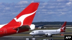 FILE - Two Qantas passenger jetsat Sydney International Airport, in Sydney, Australia, July 27, 2000. Researchers say in 2023 Australia's greenhouse gas emissions increased for the first time in five years, mostly because of an increase in post-COVID domestic air travel.