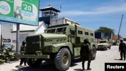 FILE - African Union peacekeepers stand next to an armored personnel carrier as they provide security for members of the Lower House of Parliament who are meeting to elect a speaker, at the Aden Adde International Airport in Mogadishu, Somalia, April 27, 2022.