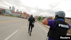 FILE - AP photojournalists John Minchillo and Julio Cortez cover continued demonstrations in reaction to the death in Minneapolis police custody of George Floyd, in Minneapolis, Minn., May 31, 2020.